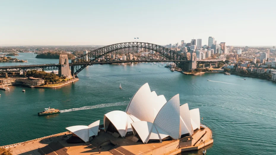 The white sails of the Sydney Opera House and the Harbour Bridge above the harbour at first light, in Australia
