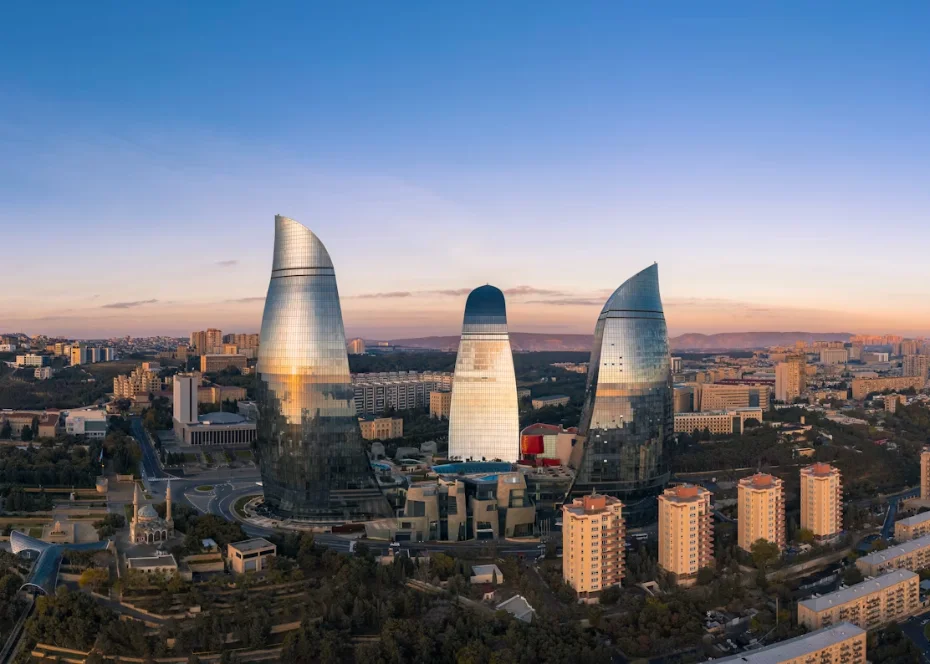 Les Flame Towers illuminées de Bakou dominant les murailles de la vieille ville d'Icheri Sheher au crépuscule, au bord de la mer Caspienne, en Azerbaïdjan